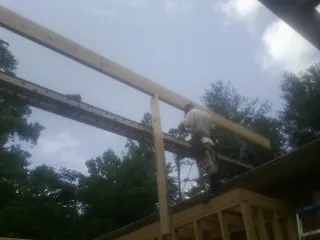 Carpenter setting a ridge beam over a new addition frame — Ice Dam Removal by Roofing Brothers in Posen