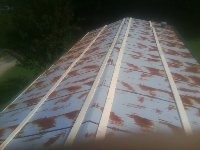 Rusted metal roof panels with new wood purlins before replacement — Storm Damage Roof Repair in Posen by Roofing Brothers