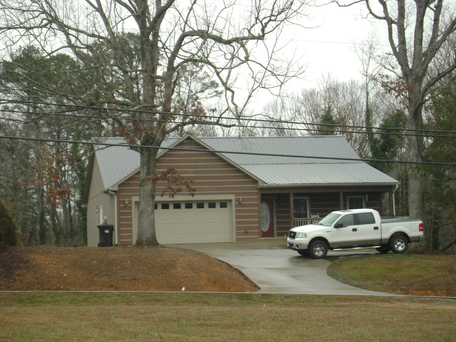 Gray metal roof on a log sided house with an attached two car garage in Posen